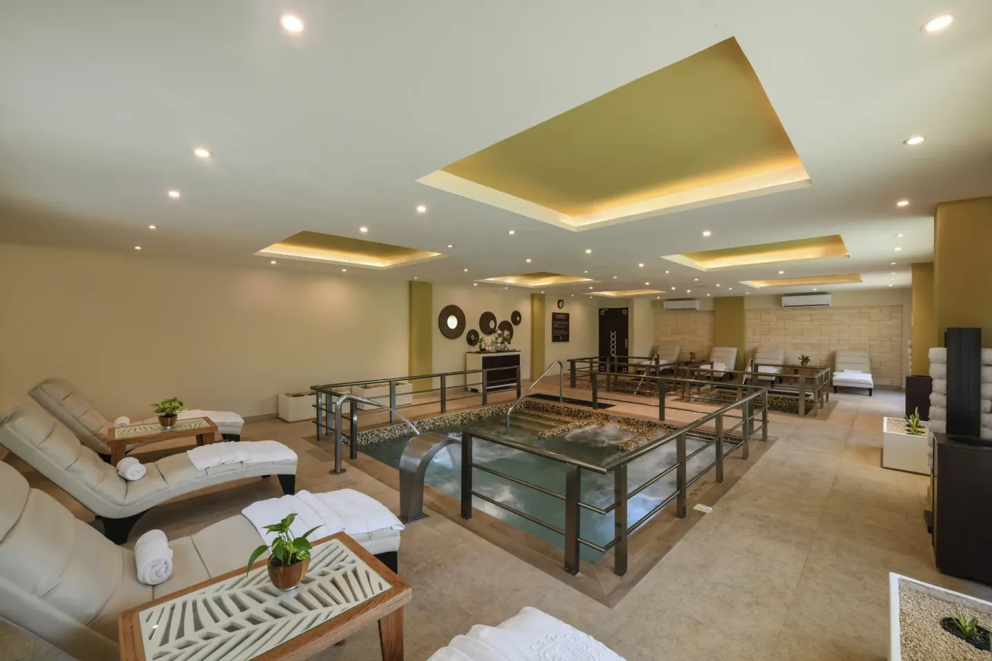 Spa relaxation area with hydrotherapy pool and lounge chairs at Palafitos Overwater Bungalows.