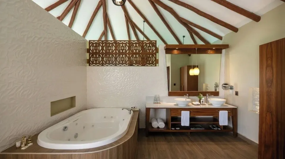 Overwater bungalow bathroom with soaking tub and double vanity at Palafitos Overwater Bungalows.