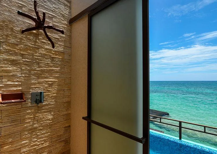 Outdoor rain shower beside the private plunge pool with an open Caribbean view in the Palafitos Elite Overwater Bungalow.