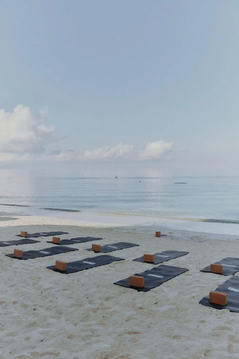 Calm sandy beach with arranged mats and wooden blocks at Palm Heights