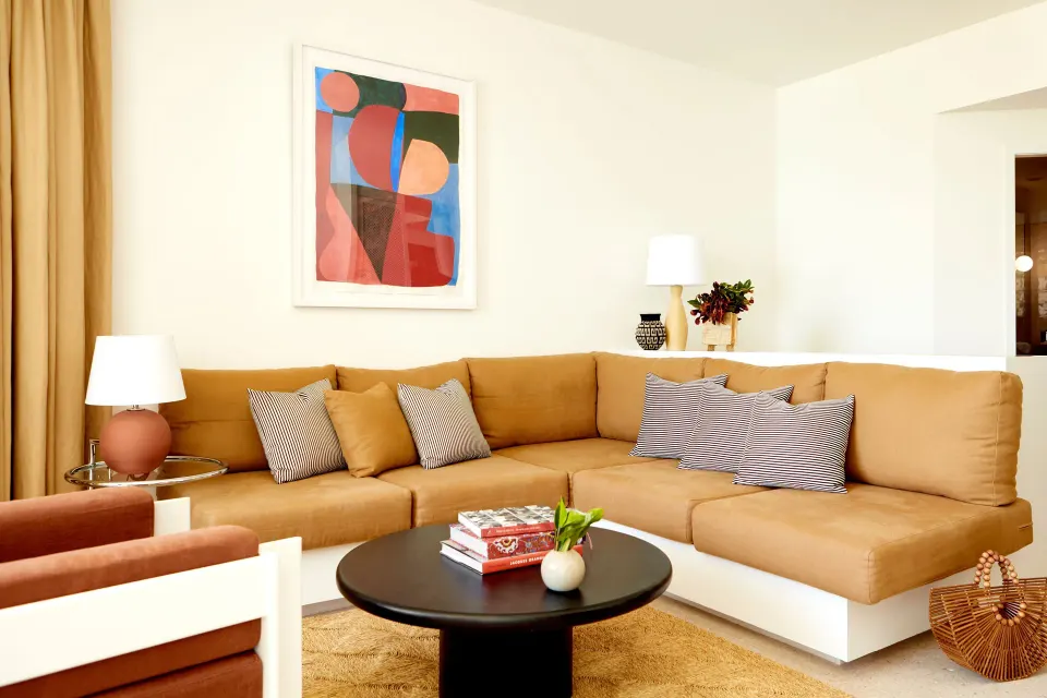 Corner sofa with decorative cushions and wall art in suite living room at Palm Heights