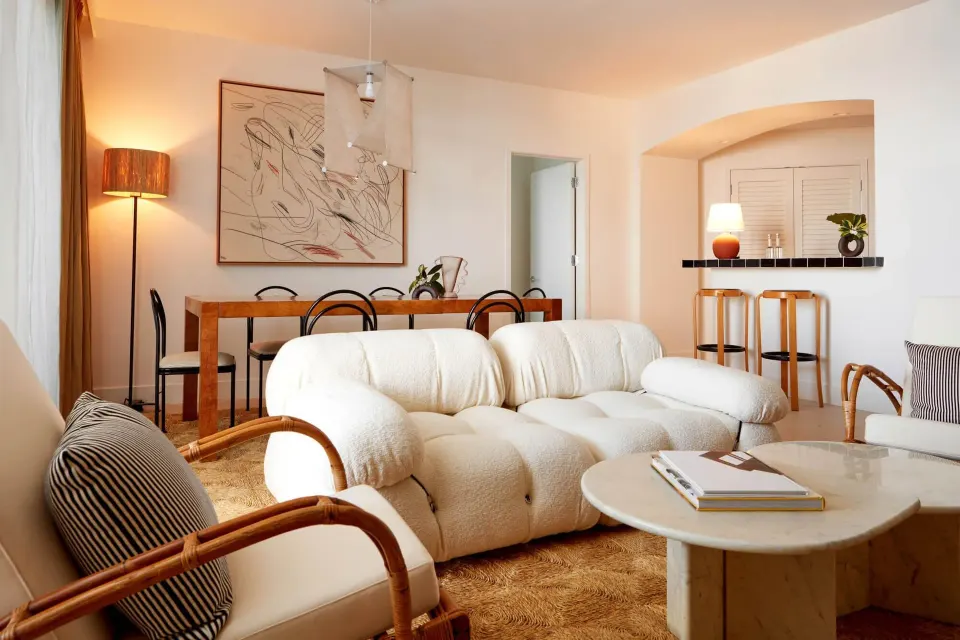Spacious living room with plush white sofas and dining table at Palm Heights