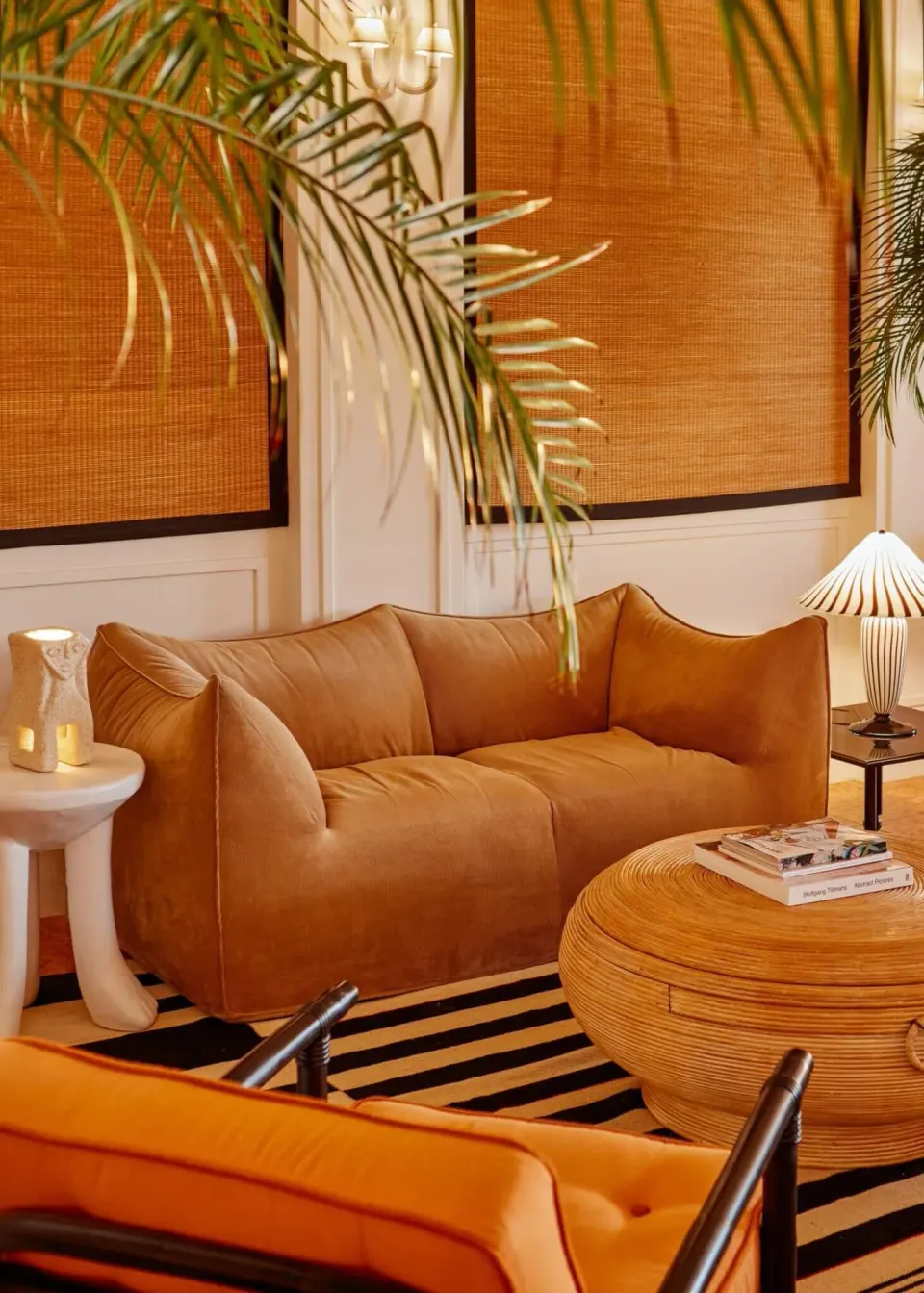Cozy lounge area with a leather sofa and round rattan table at Palm Heights.