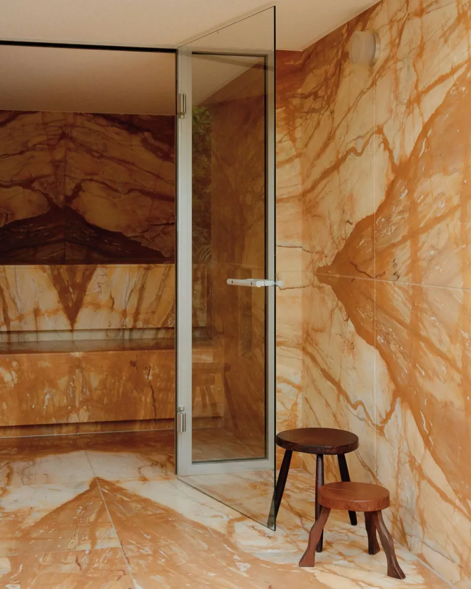 Marble-lined steam room interior with stools at Palm Heights