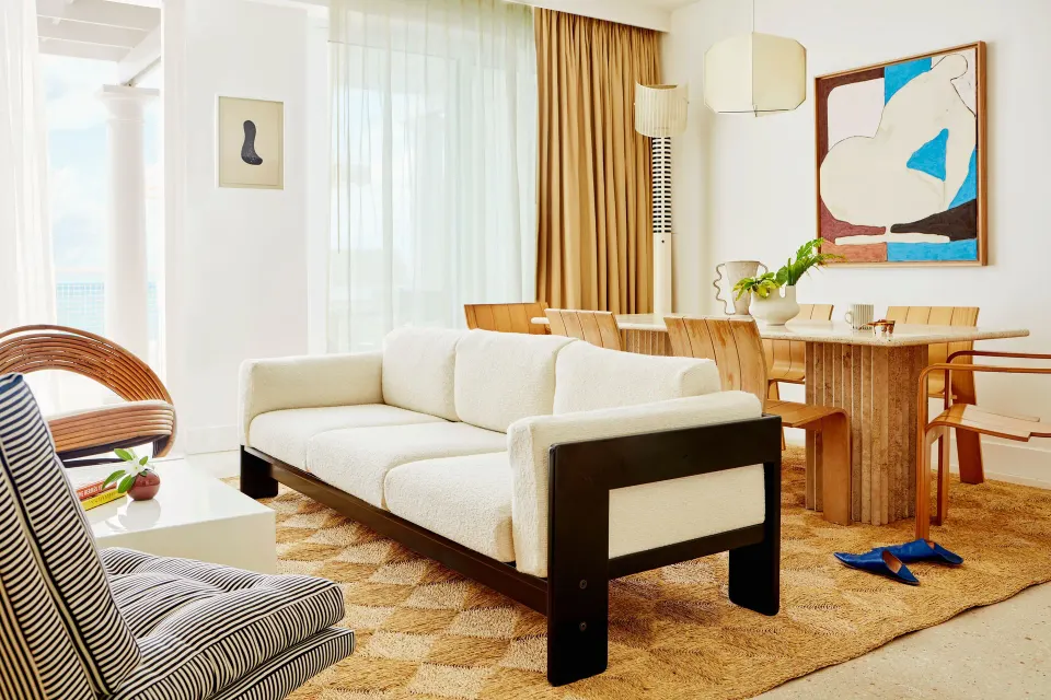 Living and dining space with white sofa and wooden dining table at Palm Heights