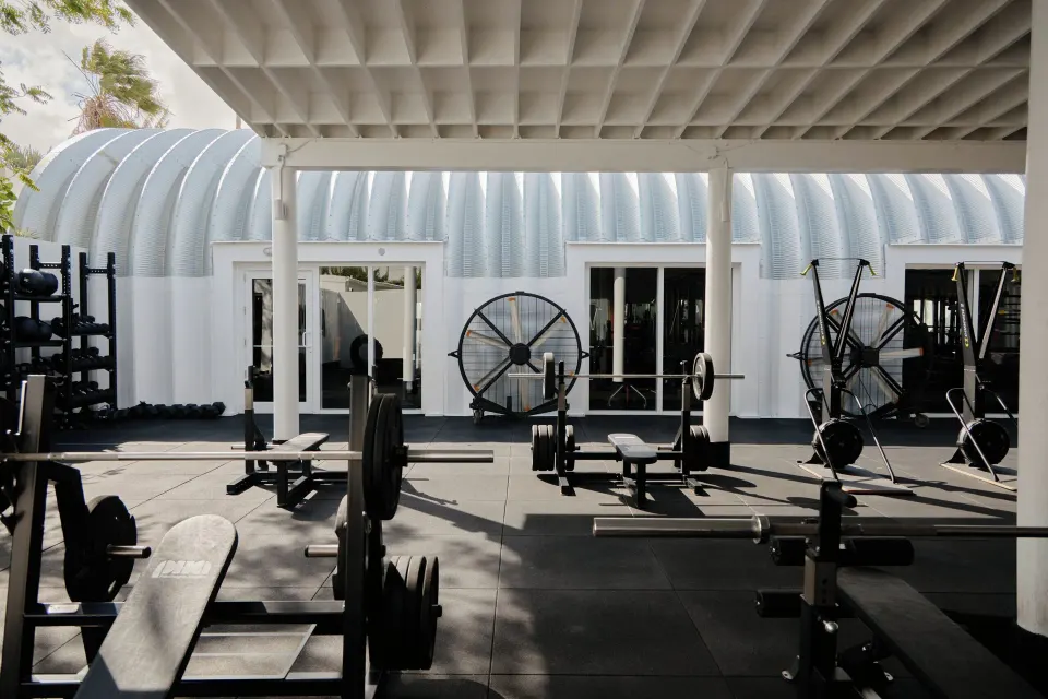 Outdoor weight training area with barbells and fans at Palm Heights
