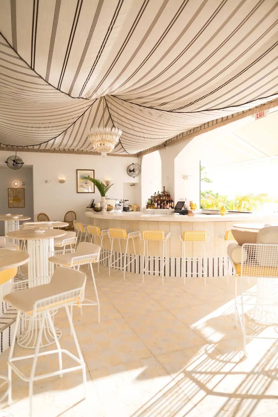 Bright striped-ceiling bar and seating area at Palm Heights.