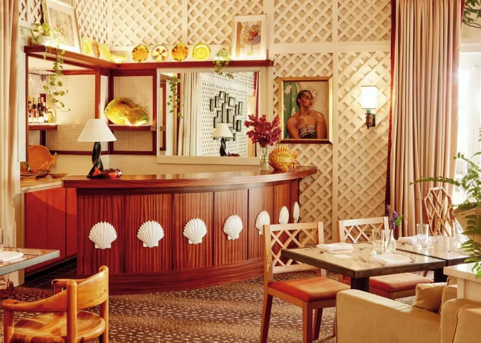 Intimate dining room with wooden shell-motif bar at Palm Heights
