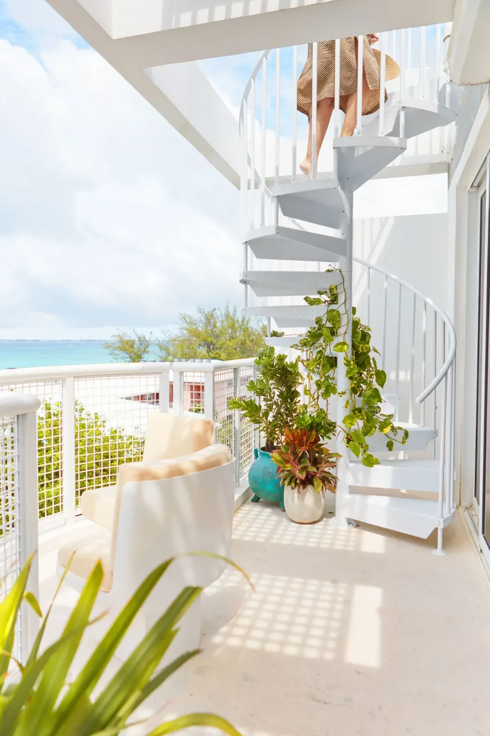 Balcony with spiral staircase and seating at Palm Heights