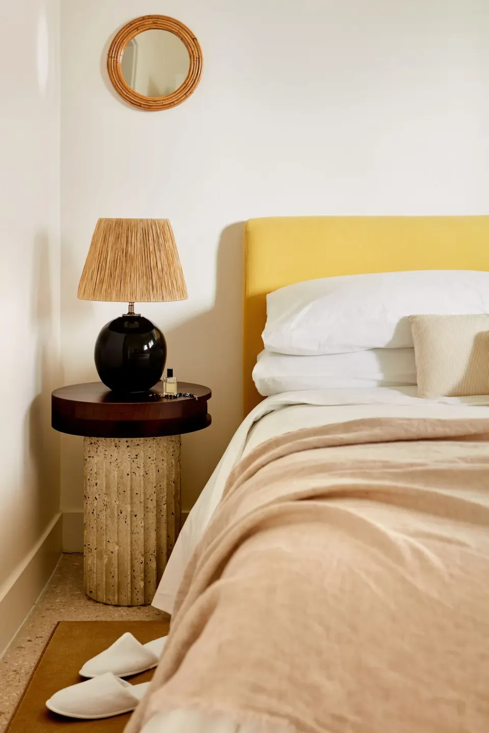 Close-up of a bedside with yellow headboard and lamp in an Ocean View Suite at Palm Heights