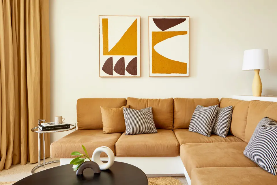 Sectional sofa with cushions and modern art in an Ocean View Suite at Palm Heights