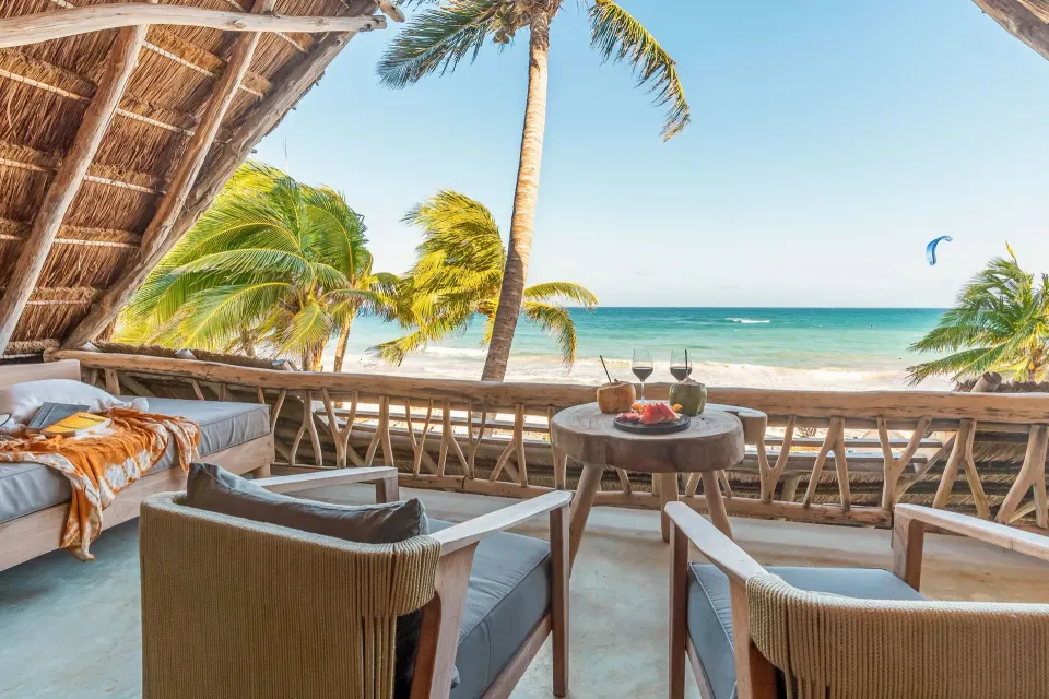 Ahau Tulum bohemian beachfront hotel with rustic palapa architecture and sandy beach setting in Tulum, Mexico.