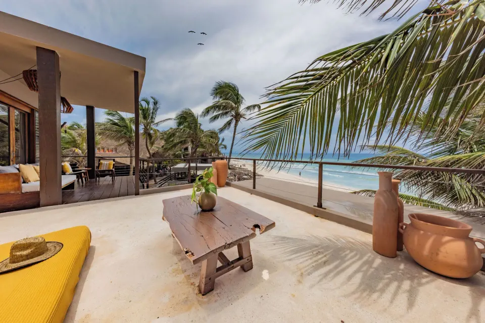 La Zebra Tulum a Small Luxury Hotel upscale boutique beachfront hotel with white sand and palapa-shaded loungers in Tulum, Mexico.