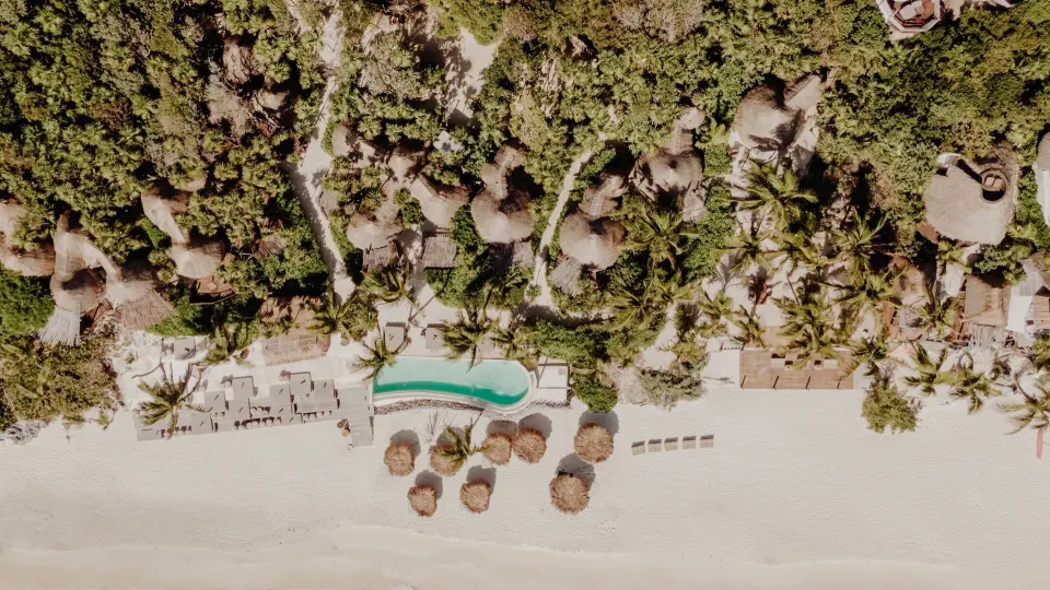 Aerial view of Papaya Playa Project showing beachfront palapas, pool and jungle villas.