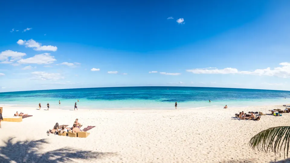 Wide shot of the white sand beach and turquoise sea at Papaya Playa Project.