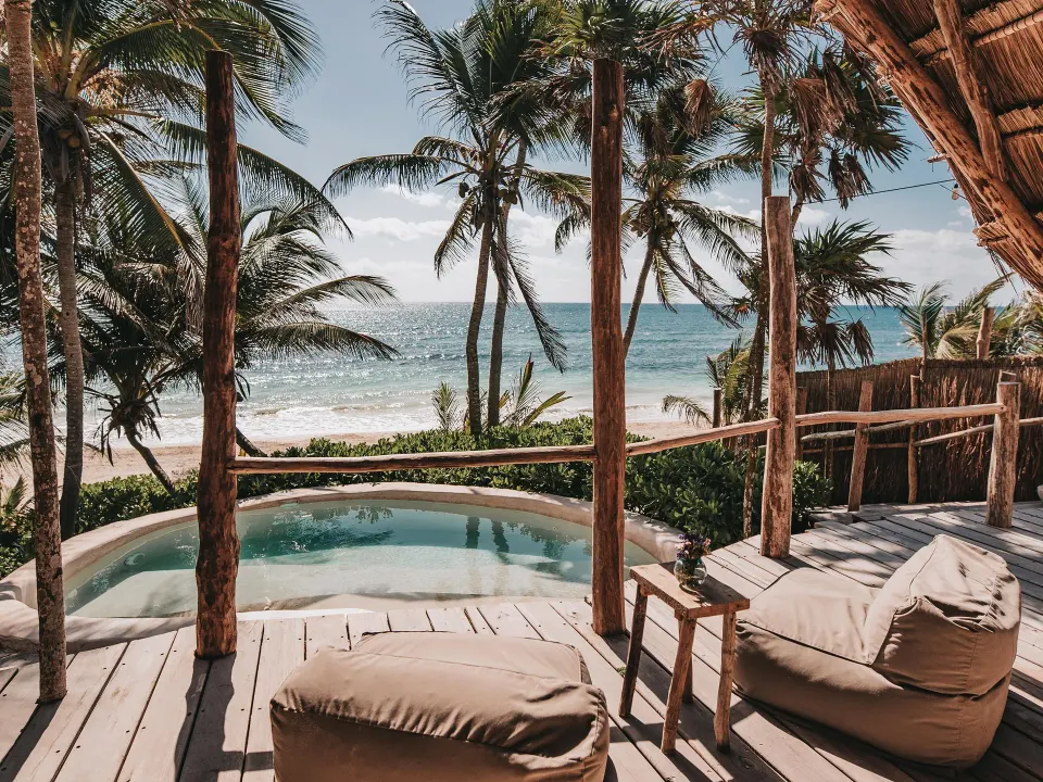 Beachfront deck with two beanbag loungers and a small plunge pool at Papaya Playa Project