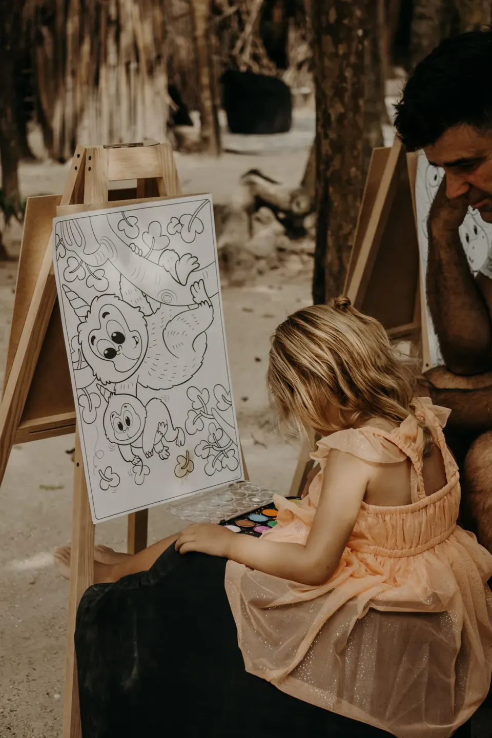 Child painting at an easel on the sand at Papaya Playa Project