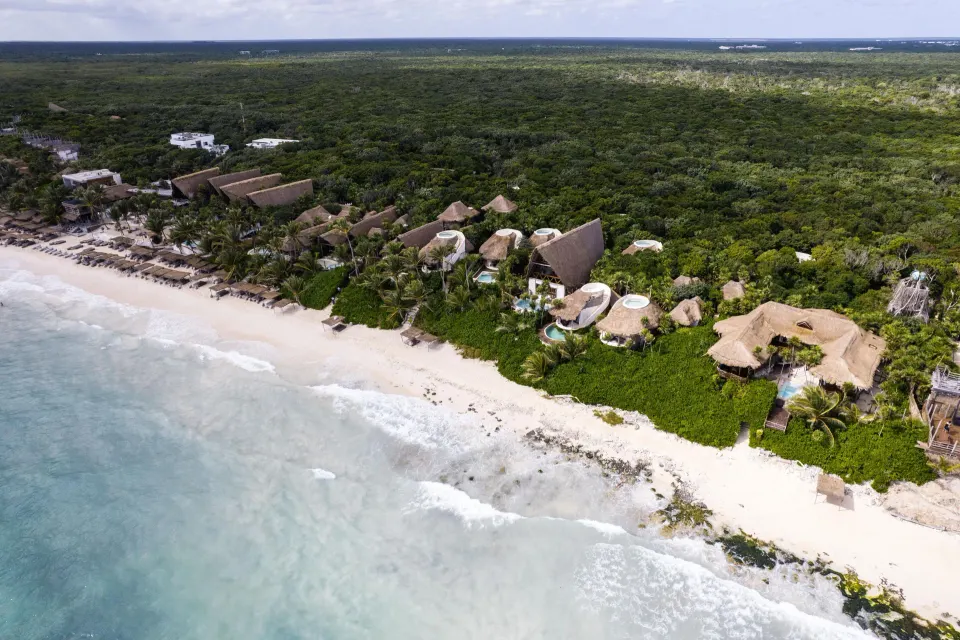 Coastal aerial of Papaya Playa Project showing villas, beach and the turquoise sea.