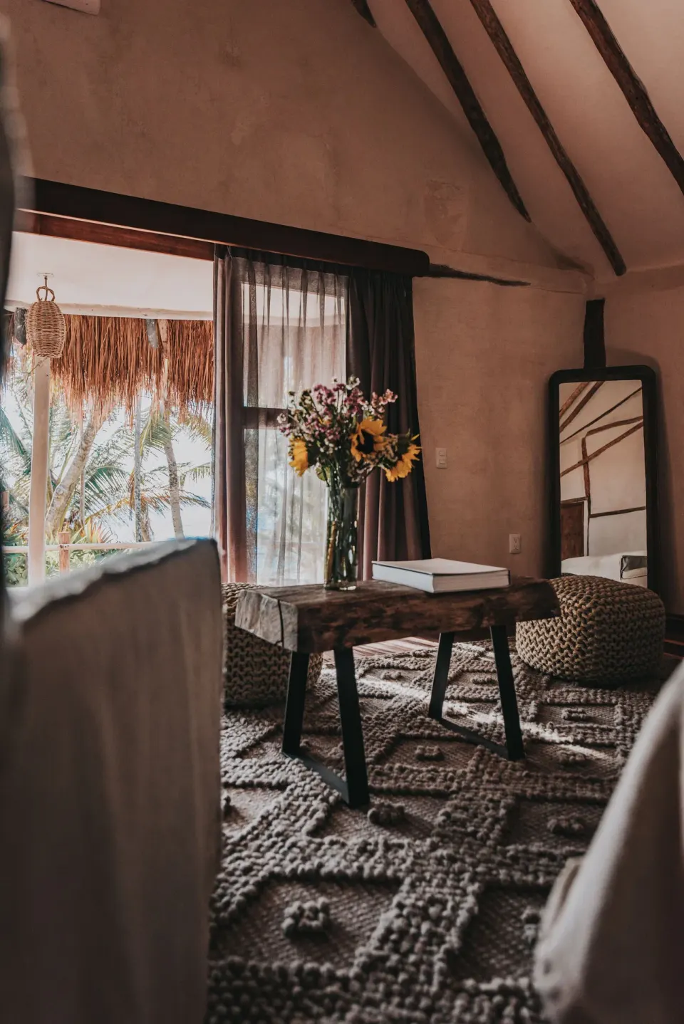 Interior corner with table, mirror and view toward the balcony at Papaya Playa Project