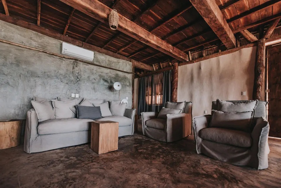 Rustic sitting area with sofa and armchairs at Papaya Playa Project