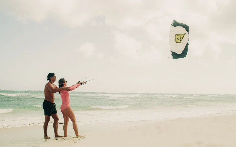Instructor guiding a guest doing kiteboarding on the beach at Papaya Playa Project.