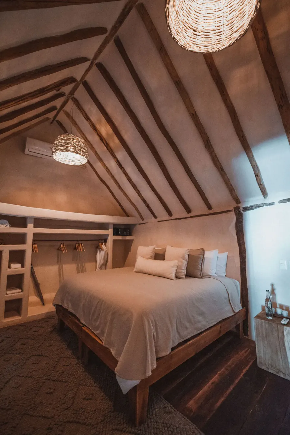 Cozy loft bedroom with exposed beams and a king bed at Papaya Playa Project
