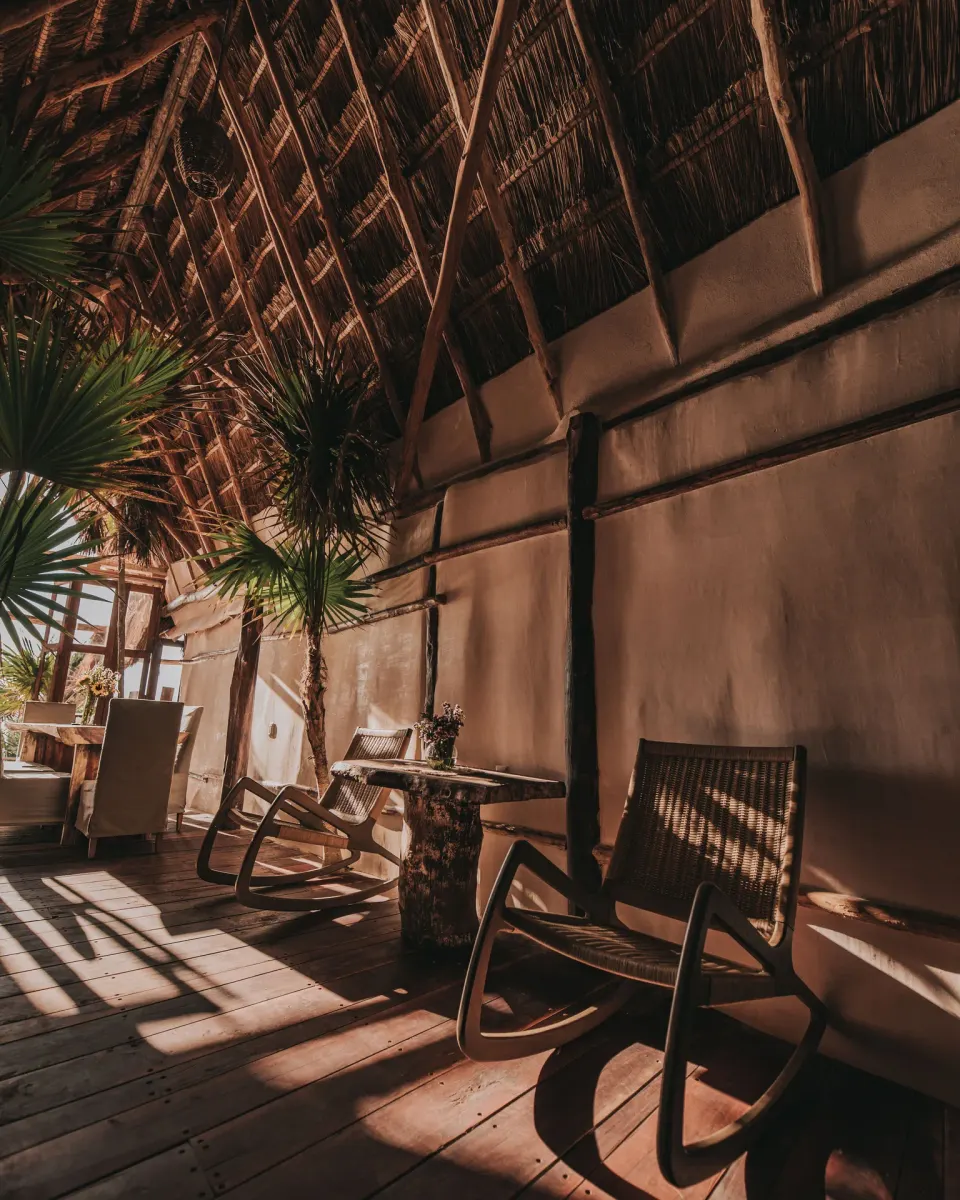 Shaded palapa lounge with rocking chairs at Papaya Playa Project