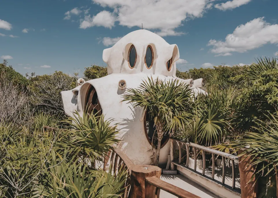 Organic white sculpted dome structure among palms at Papaya Playa Project