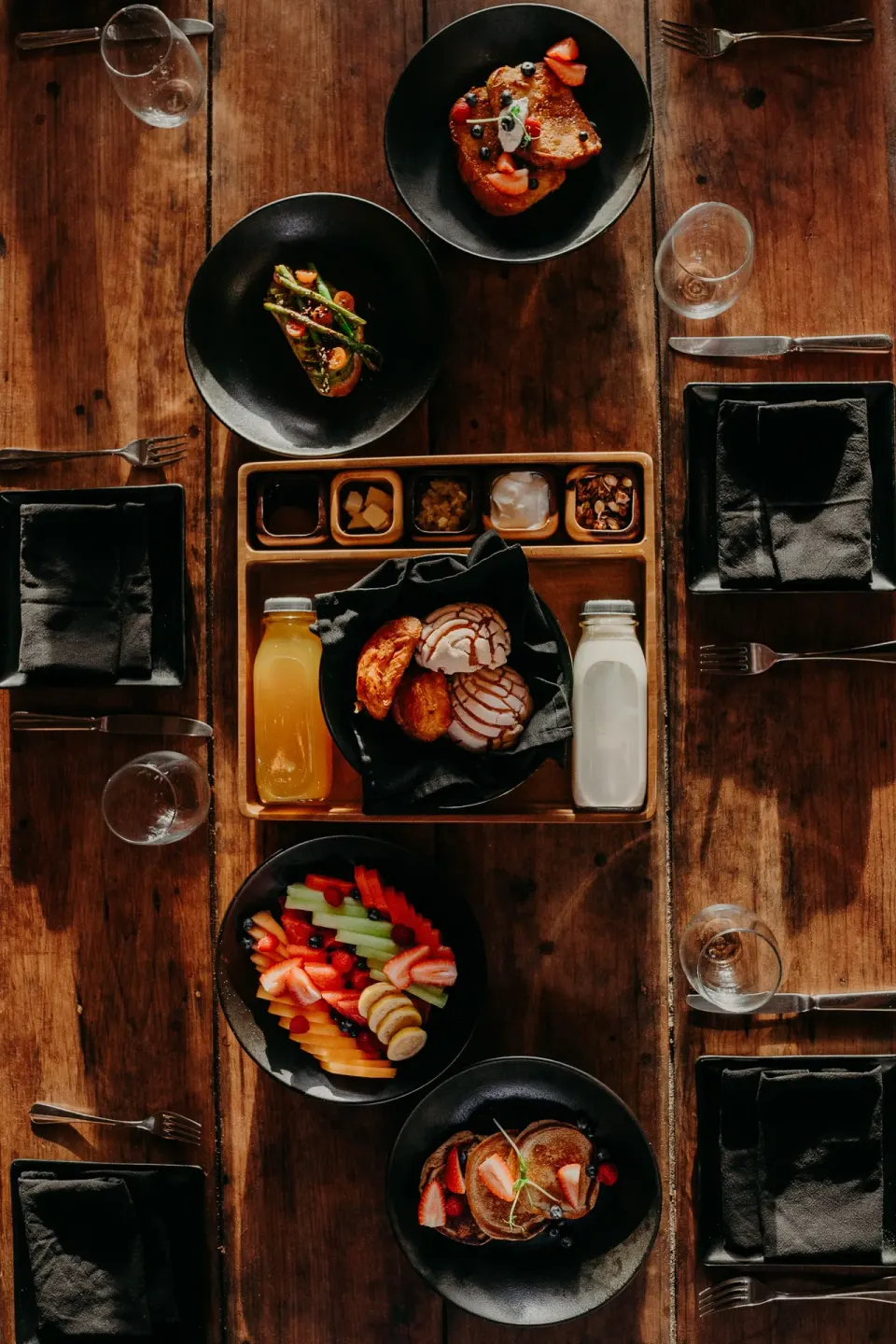Table set for breakfast with multiple bowls and a central tray at Papaya Playa Project