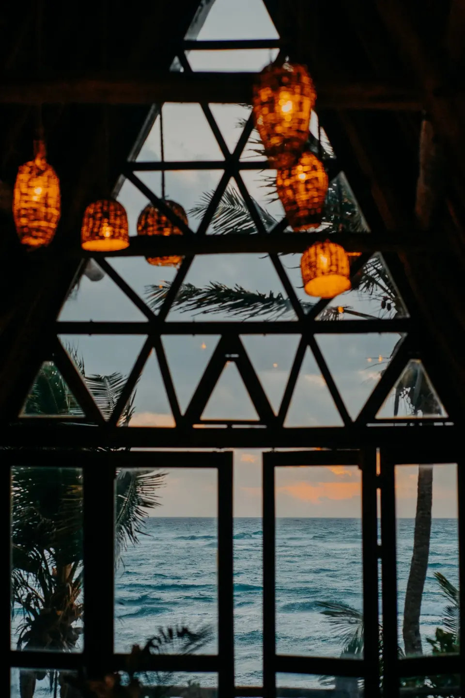 Ocean view through triangular windows and hanging lamps at Papaya Playa Project