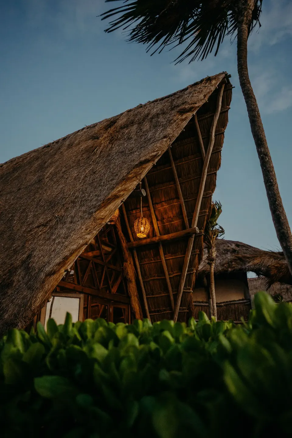 Thatched open-air pavilion roof and warm pendant light at Papaya Playa Project
