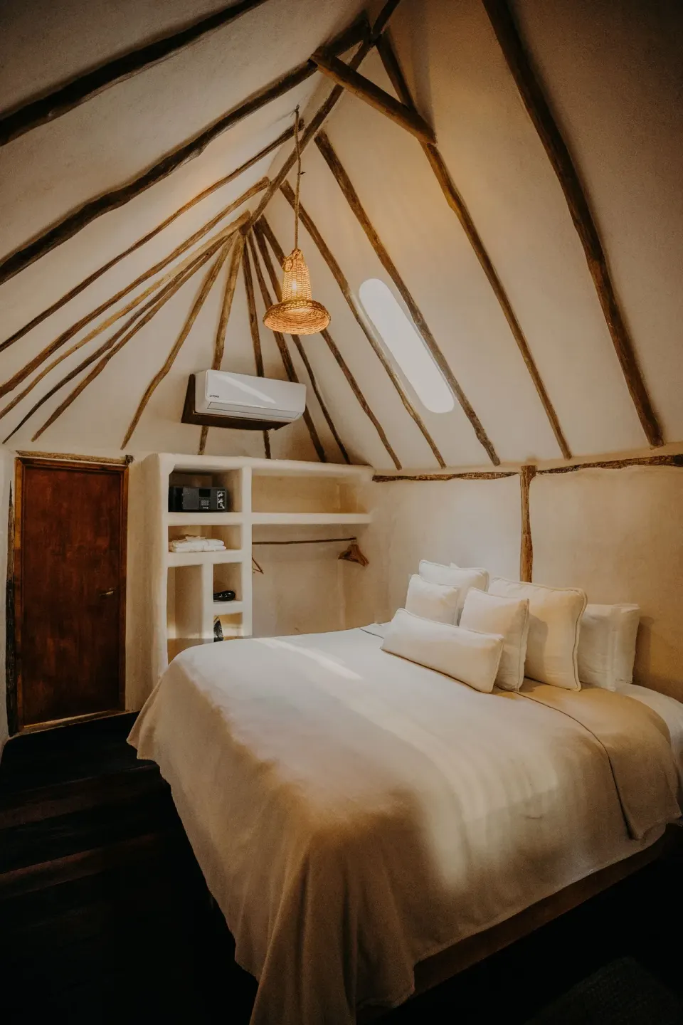 Cozy bedroom interior of Casa Arena with king bed and exposed roof beams at Papaya Playa Project