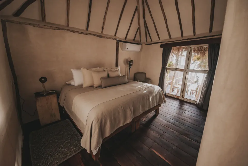 King bed and balcony doors in a simple bedroom at Casa Palma, Papaya Playa Project