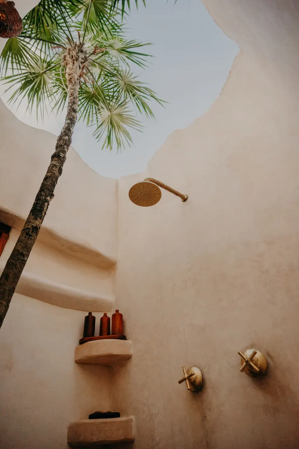 Open-air shower in the Casa Palma room at Papaya Playa Project with a palm visible through the skylight.
