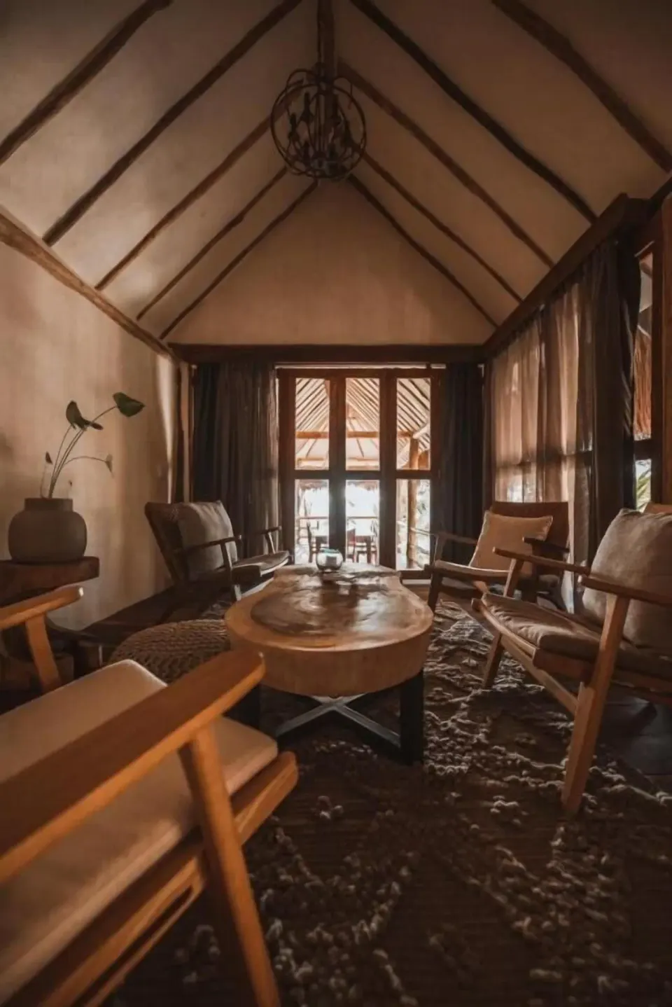 Lounge area with circular coffee table and chairs facing balcony in Casa Palma at Papaya Playa Project