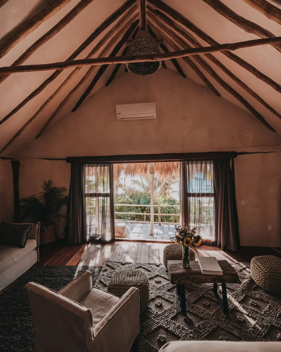 Sitting area and sliding doors to a thatched balcony in Casa Palma at Papaya Playa Project