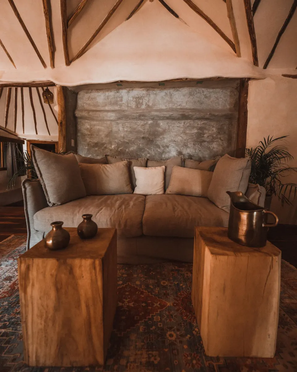 Plush sofa with wooden side tables in Casa Palma lounge at Papaya Playa Project
