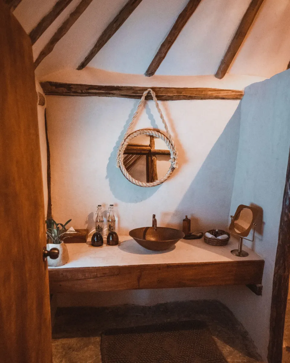 Bathroom vanity with vessel sink and round mirror in Casa Viento at Papaya Playa Project