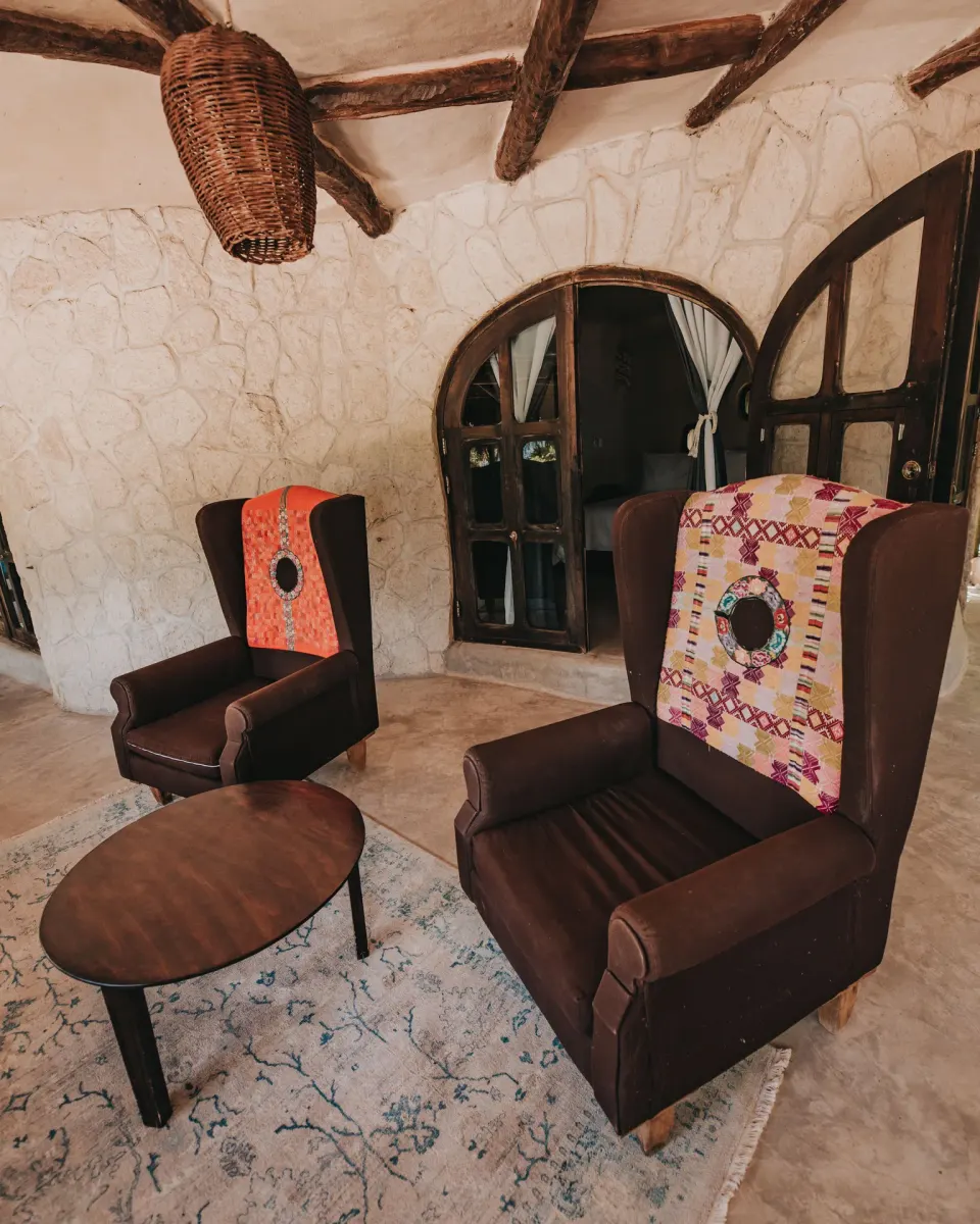 Two high-backed lounge chairs with woven throws in Casa Viento at Papaya Playa Project