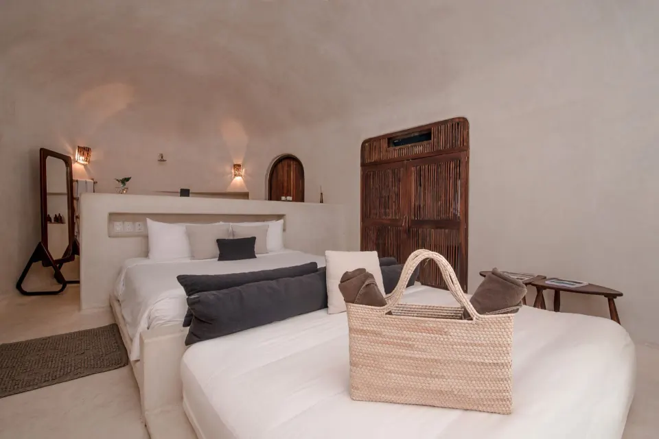 Interior of a casita bedroom with two beds and rustic decor at Papaya Playa Project