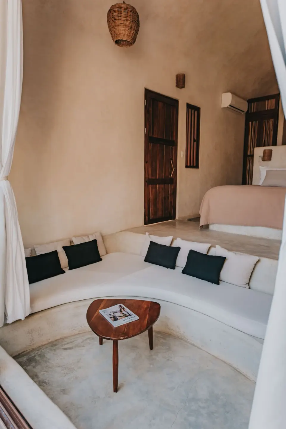 Curved built-in sofa and partial bed inside a casita at Papaya Playa Project