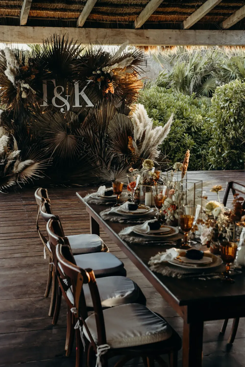 Long wooden dining table set for an event under a palapa at Papaya Playa Project.