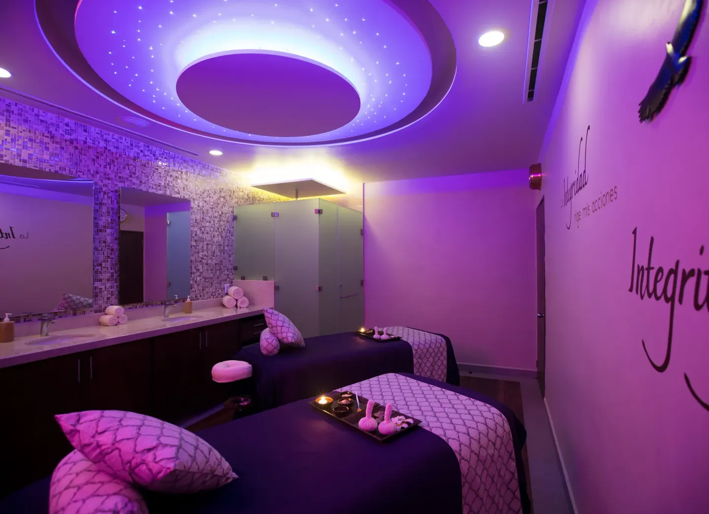 Spa treatment room with two massage tables and purple lighting at Paradise Village Beach Resort and Spa.
