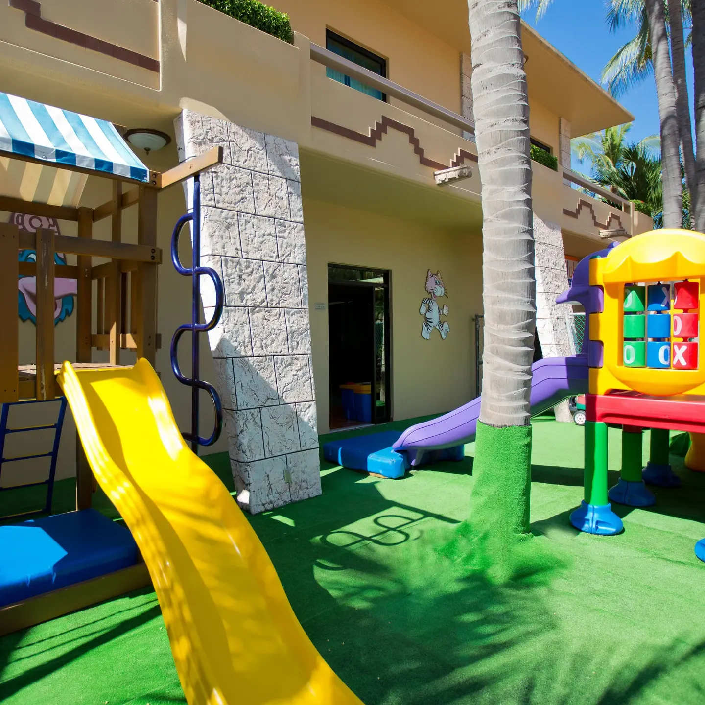 Outdoor children's play area at Paradise Village Beach Resort and Spa with slides and colorful equipment.