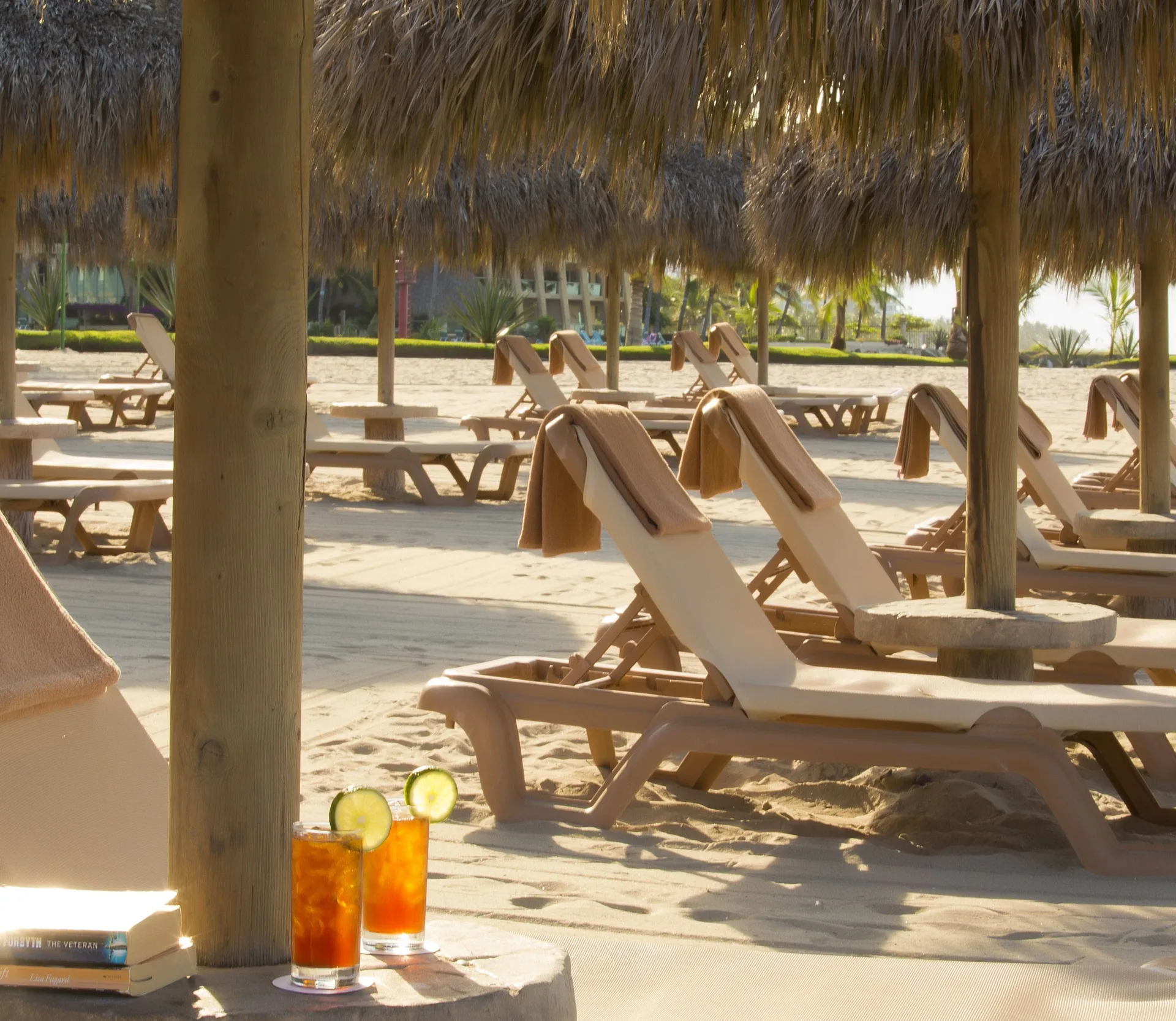 Shaded beach loungers and two cold drinks at Paradise Village Beach Resort and Spa.
