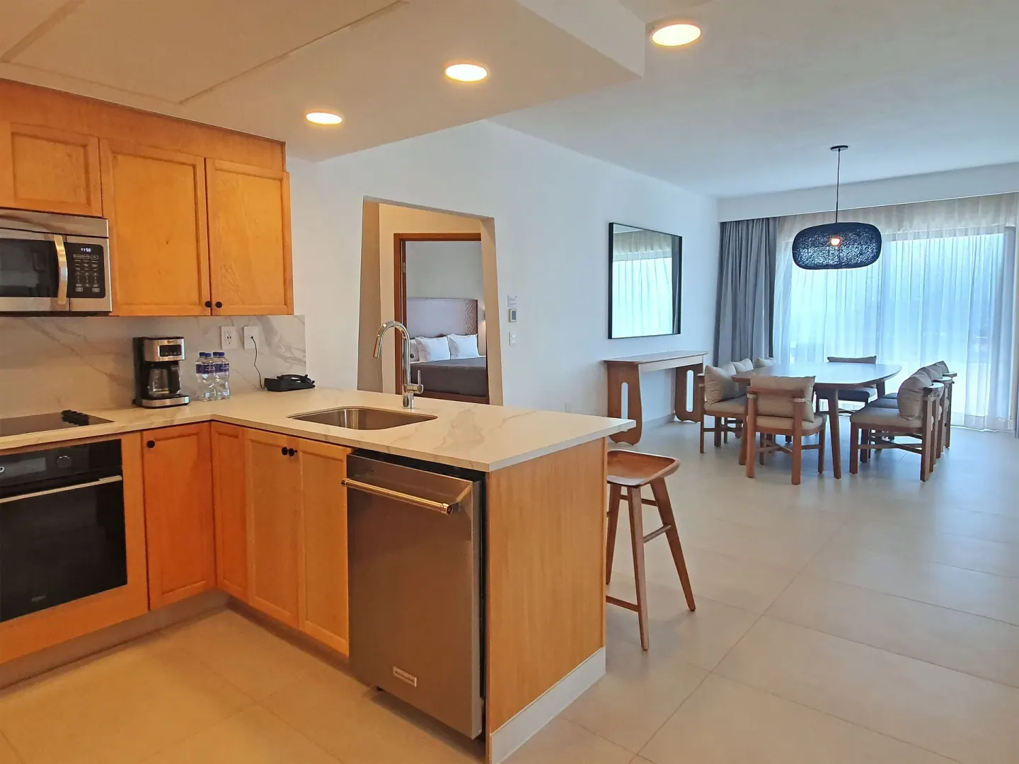 Modern suite kitchen with dining area and bedroom doorway at Paradise Village Beach Resort and Spa.