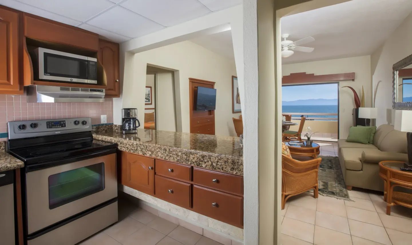 Suite kitchen and living room with ocean view balcony at Paradise Village Beach Resort and Spa.