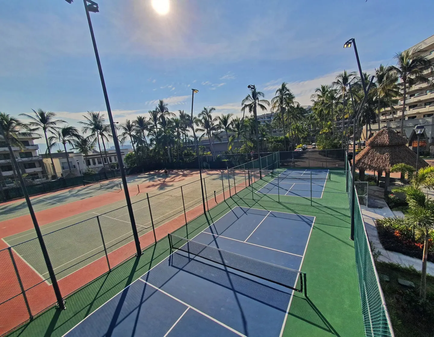 Tennis and pickleball courts at Paradise Village Beach Resort and Spa with palms and resort buildings.
