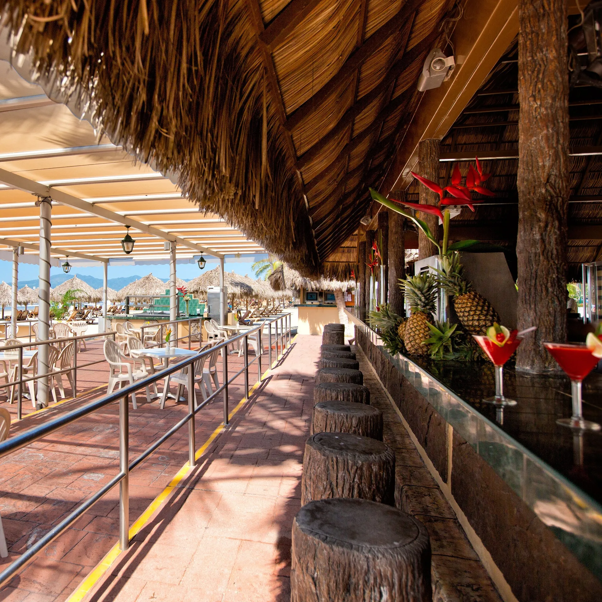 Thatched beach bar walkway with stools at Paradise Village Beach Resort and Spa.