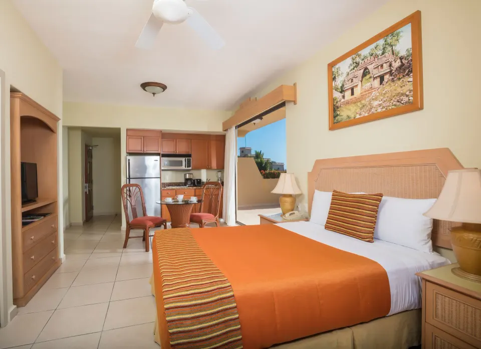 Standard Studio Suite king bed, kitchenette, and balcony at Paradise Village Beach Resort and Spa.
